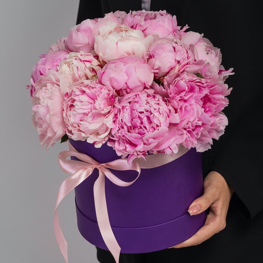Праздничная композиция из 15 пионов в сиреневой шляпной коробке