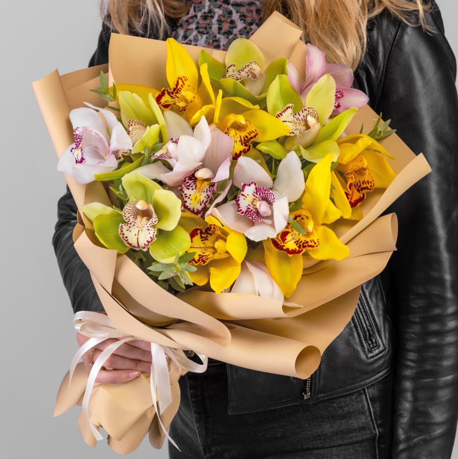 Красочный букет из 15 микс Орхидей в матовой бумаге с зеленью