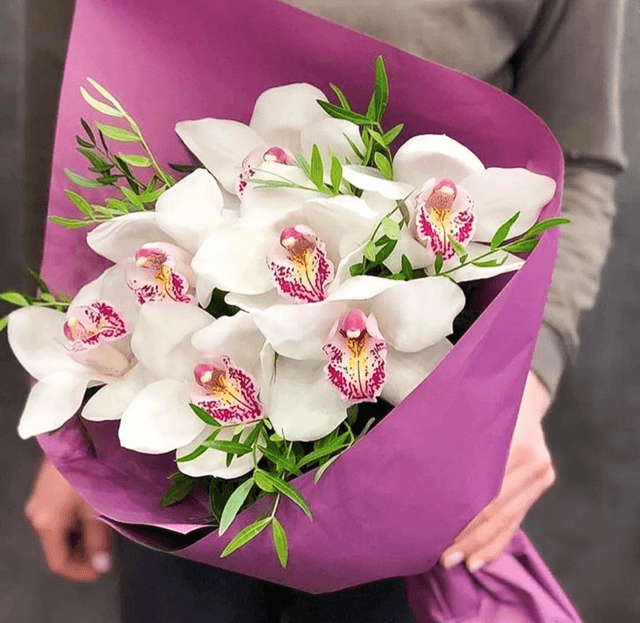 Оригинальный букет из 7 Орхидей в матовой бумаге с зеленью Оригинальный букет из 7 Орхидей в матовой бумаге с зеленью