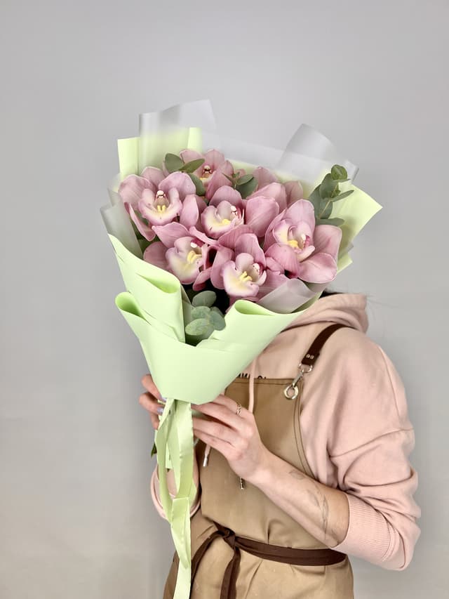 Шикарный букет из 7 розовых Орхидей в матовой бумаге с зеленью Шикарный букет из 7 розовых Орхидей в матовой бумаге с зеленью