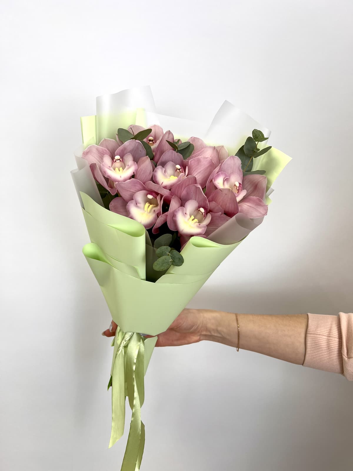 Шикарный букет из 7 розовых Орхидей в матовой бумаге с зеленью