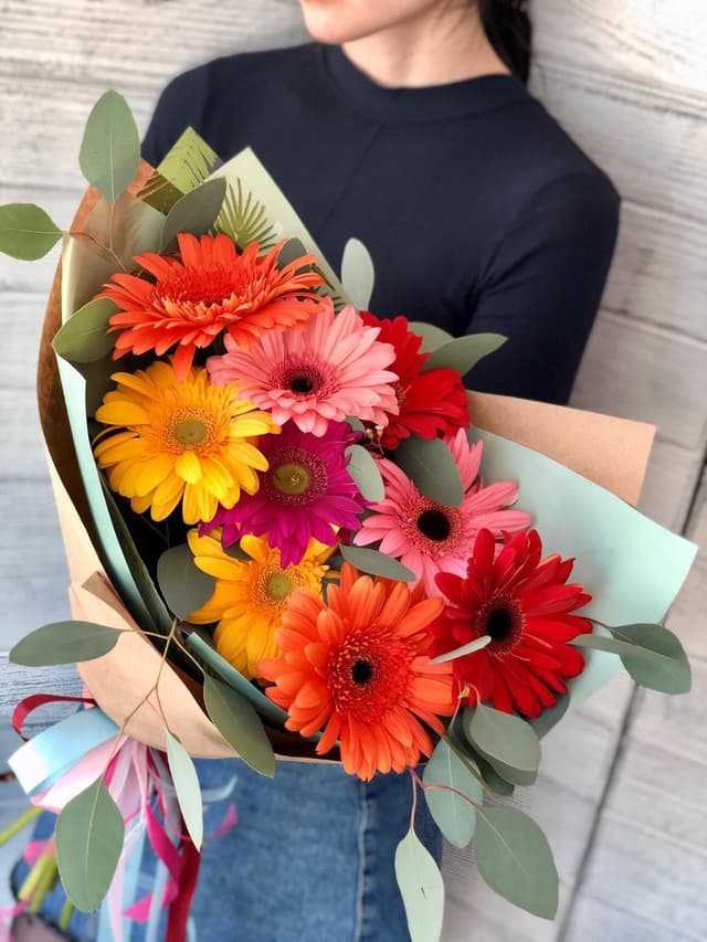 Весенний букет из 9 гербер в крафте с зеленью Весенний букет из 9 гербер в крафте с зеленью