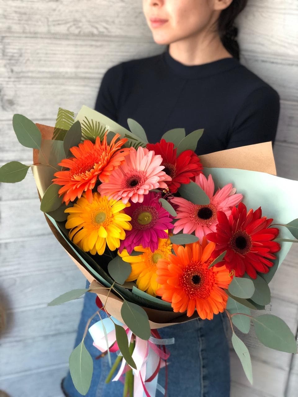 Весенний букет из 9 гербер в крафте с зеленью