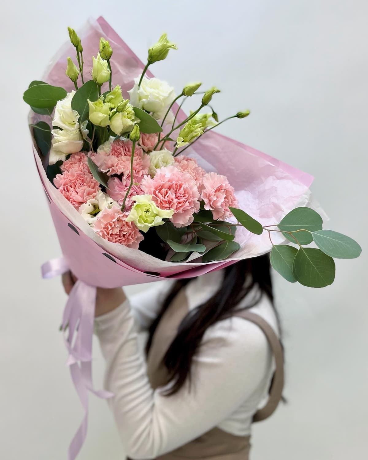 Красивый букет из диантусов и эустом в матовой бумаге розовый